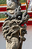 Bangkok Wat Arun - Detail of stone pillars with entwined dragons at the second entrace gate of the ubosot. 